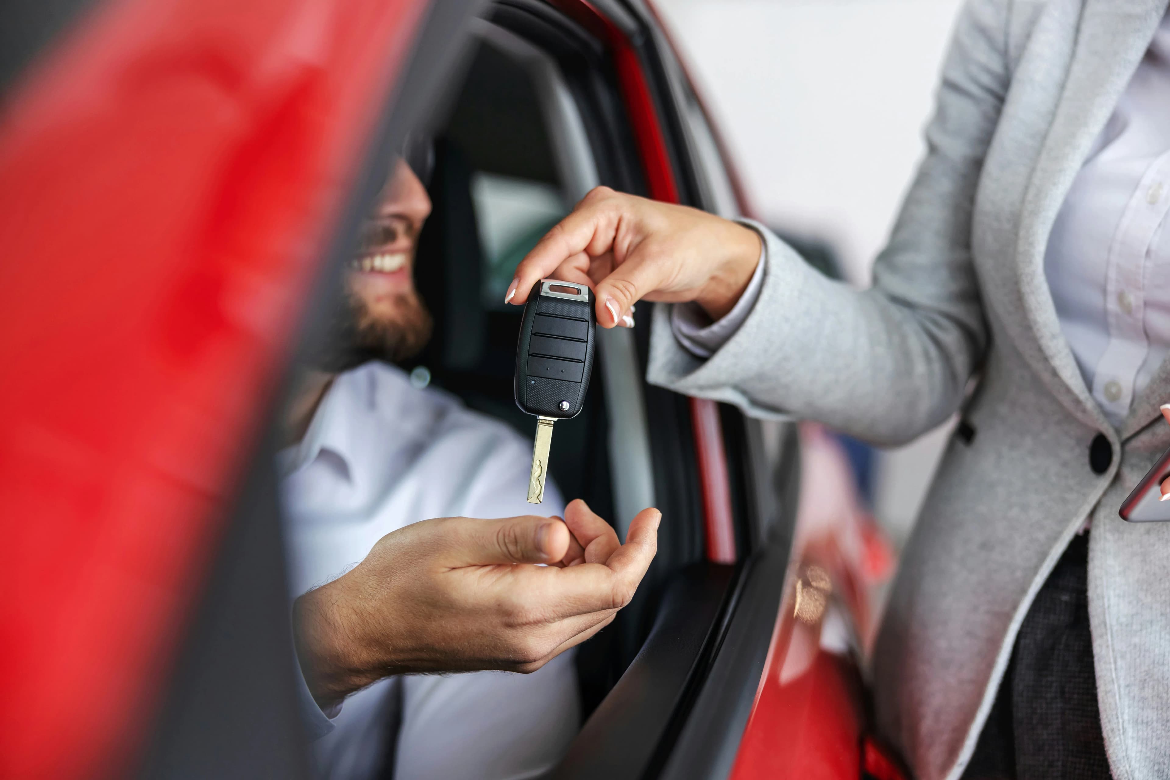 Dealer handing keys at a vehicle
