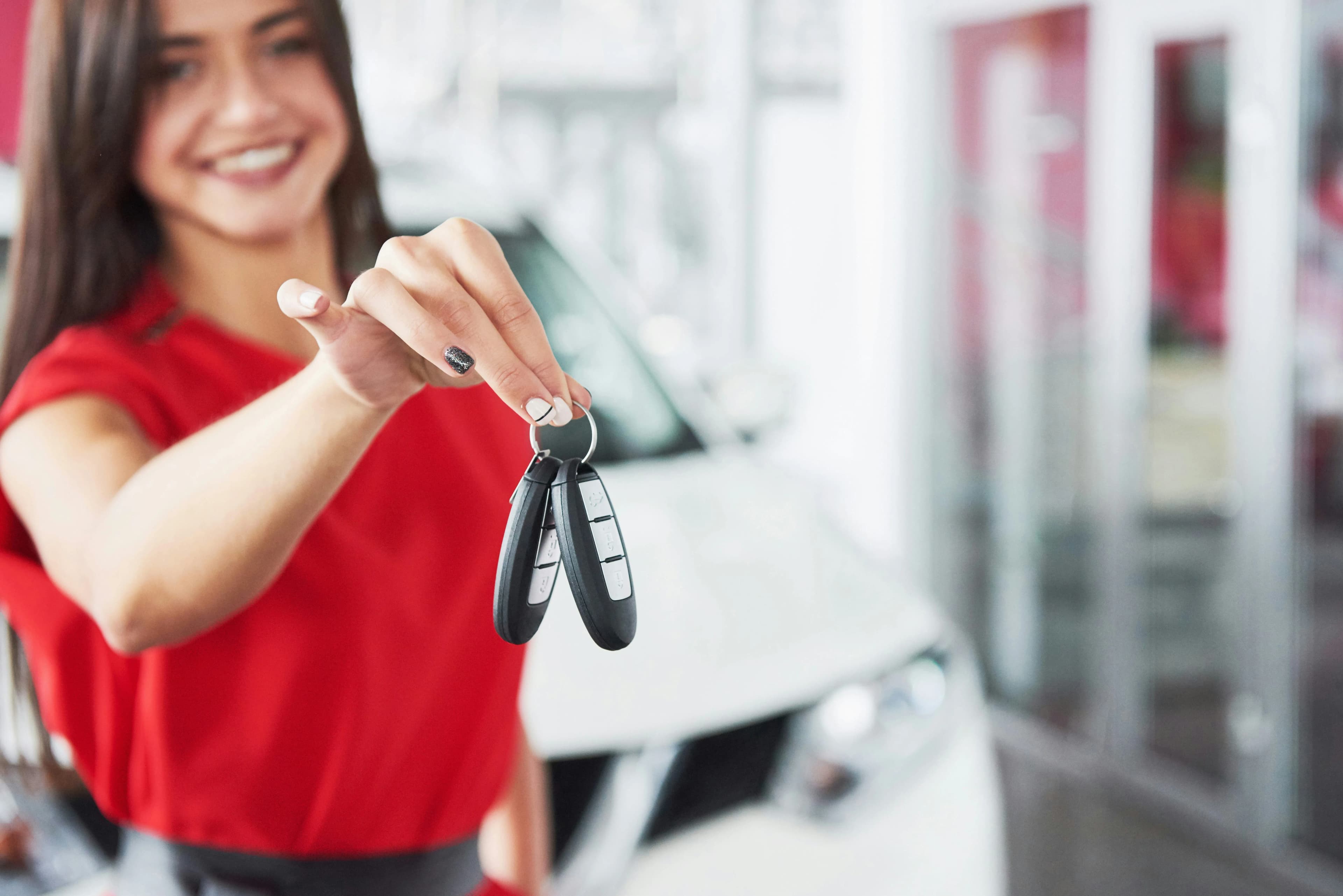 Dealer representative handing car keys with a smile