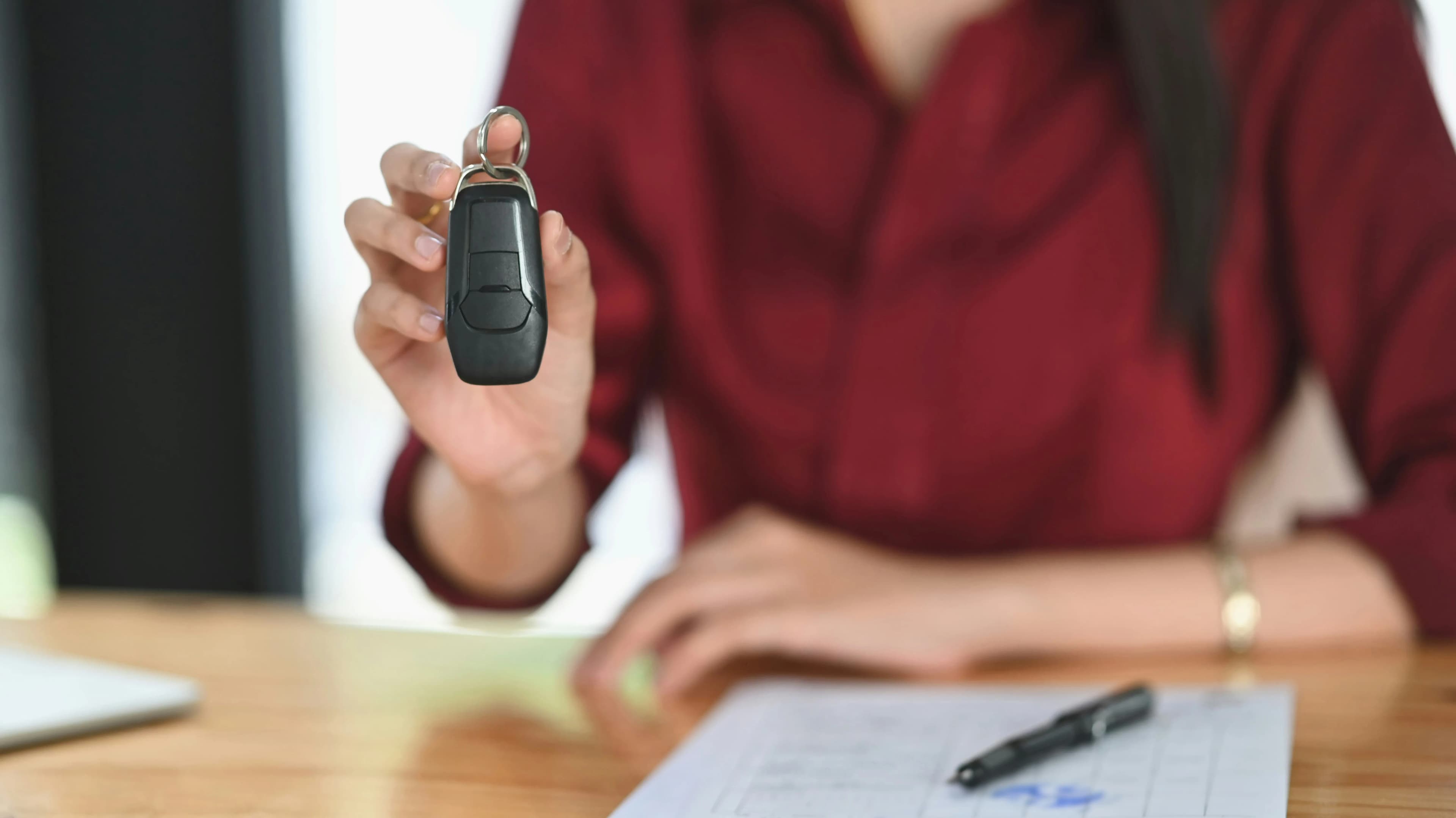 Desk with contract, pen, and car key