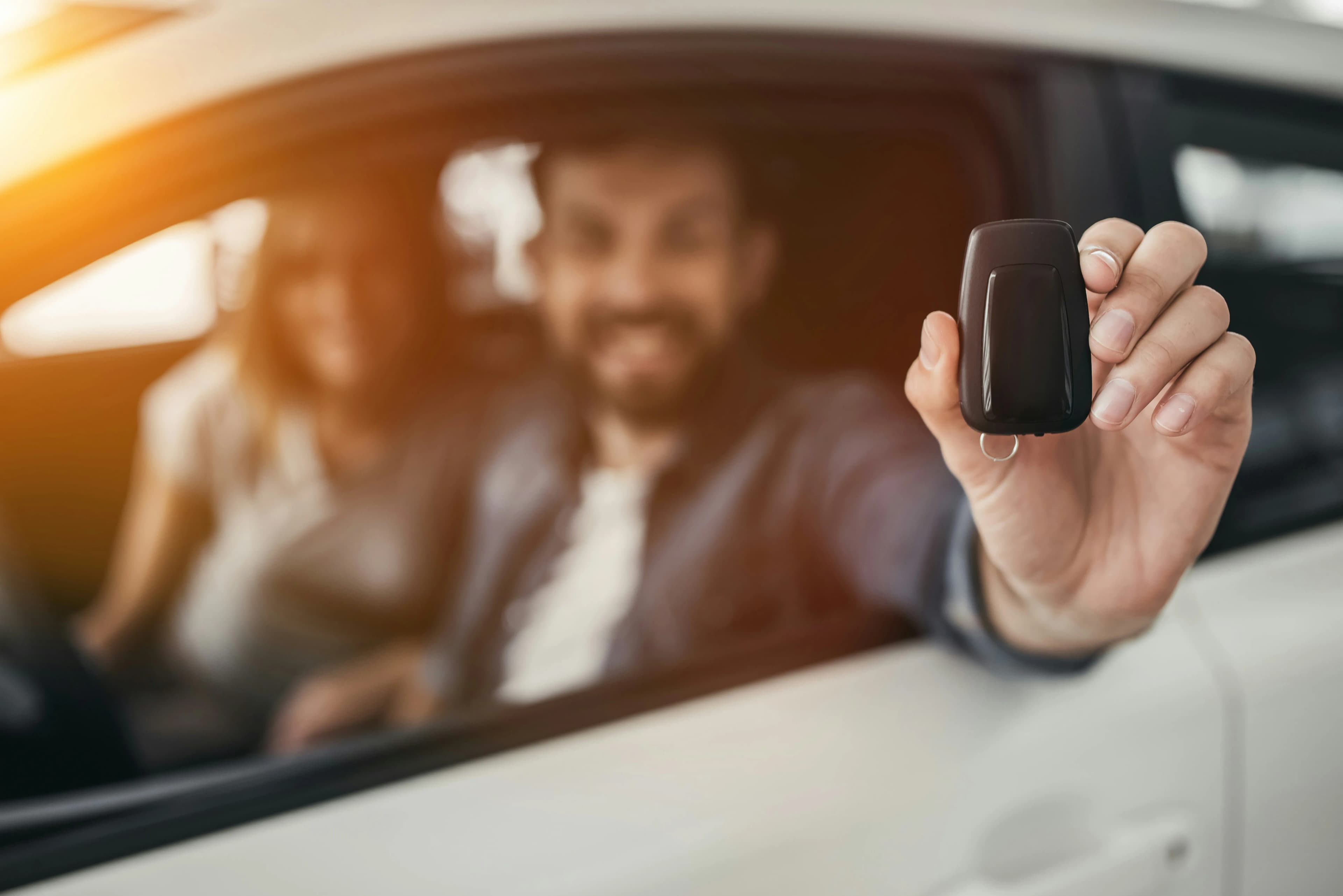Happy couple in a vehicle with a key fob
