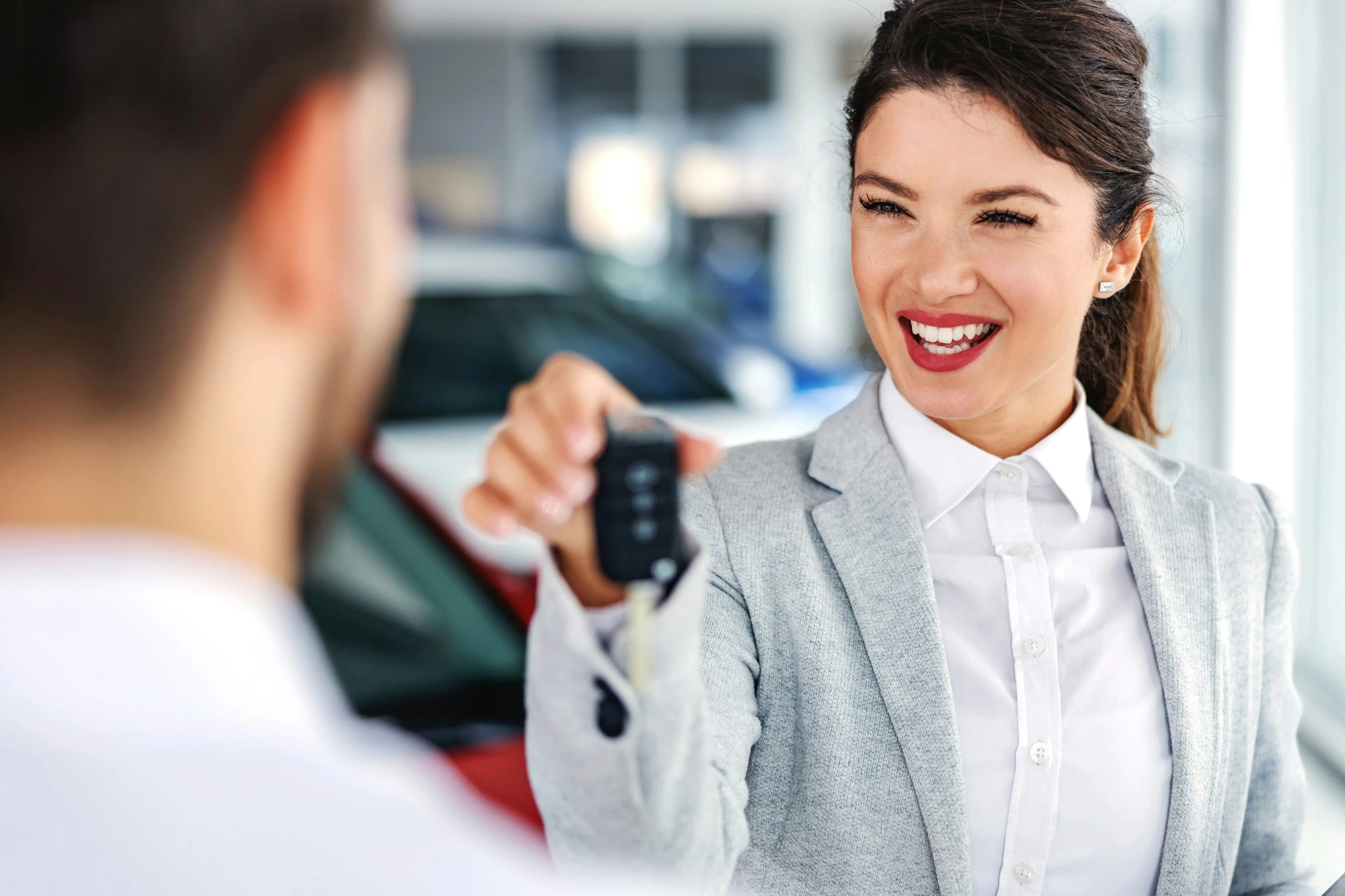 Professional dealer handing keys in a showroom