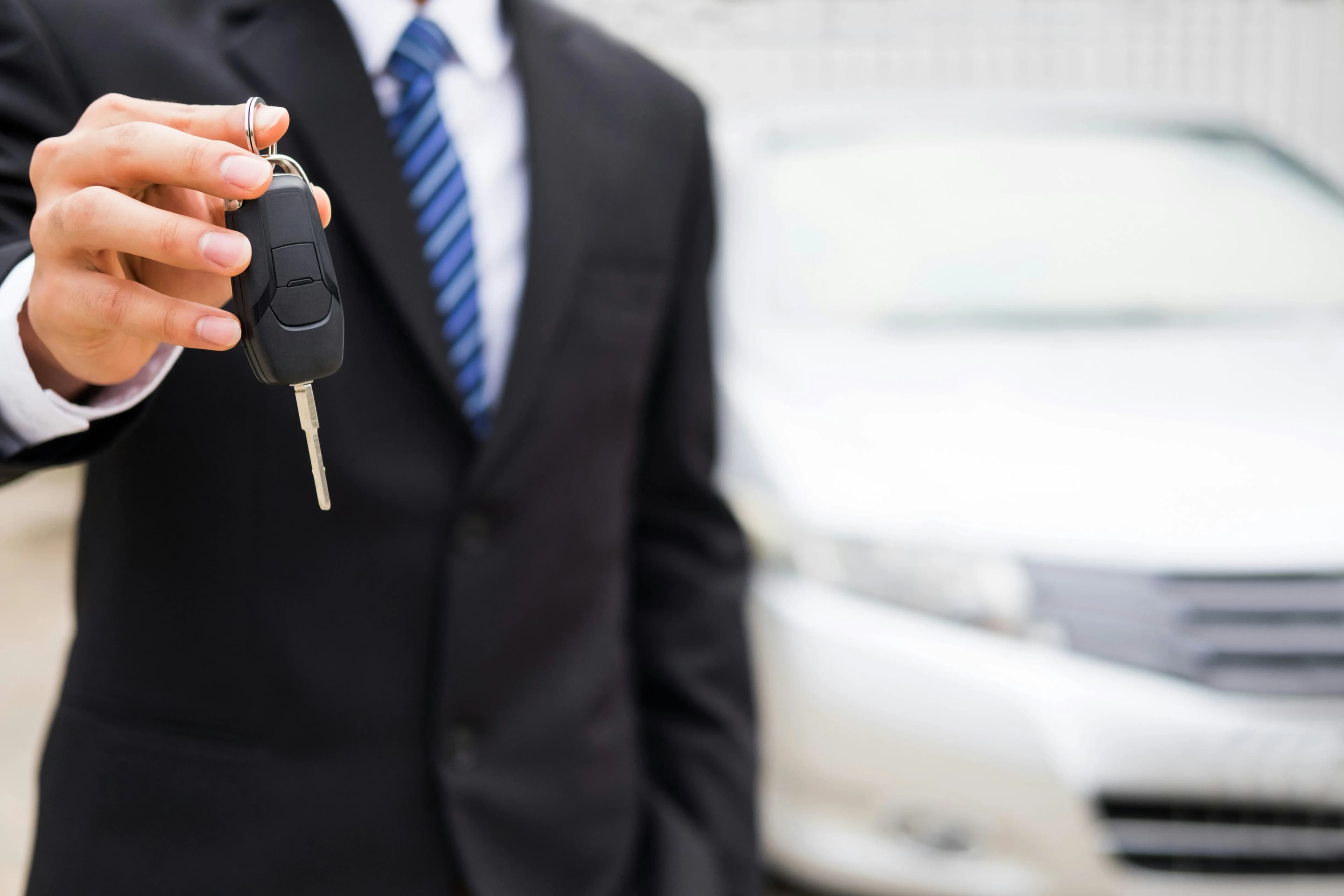 Sales professional offering a car key
